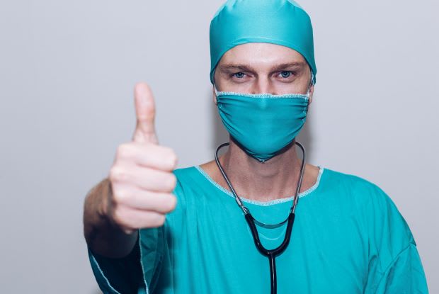 a doctor holding up a thumbs-up