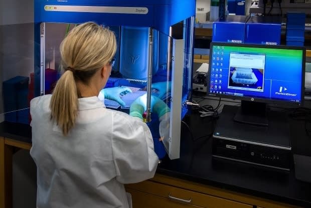 a scientist testing samples on a machine