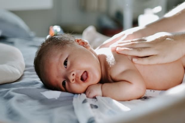 a newborn baby on a table with a blanket