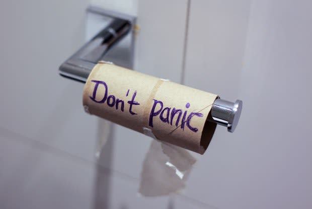 “don’t panic” written on a toilet paper roll