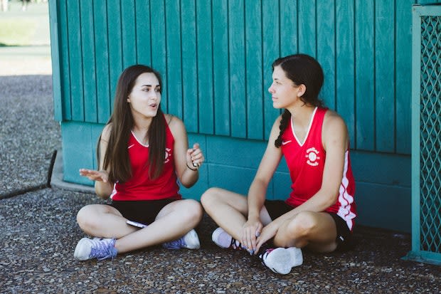 two student-athletes resting in the shade