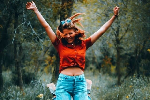 a woman extremely happy with her arms raised above her