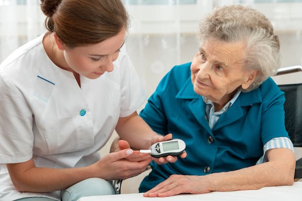 a nurse taking an older woman’s blood sugar level