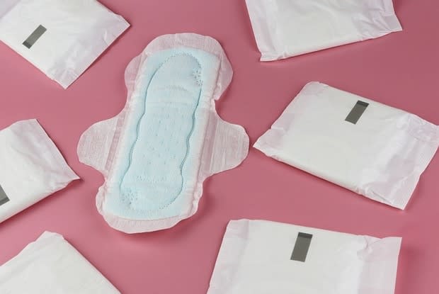 an open sanitary pad surrounded by unopened pads