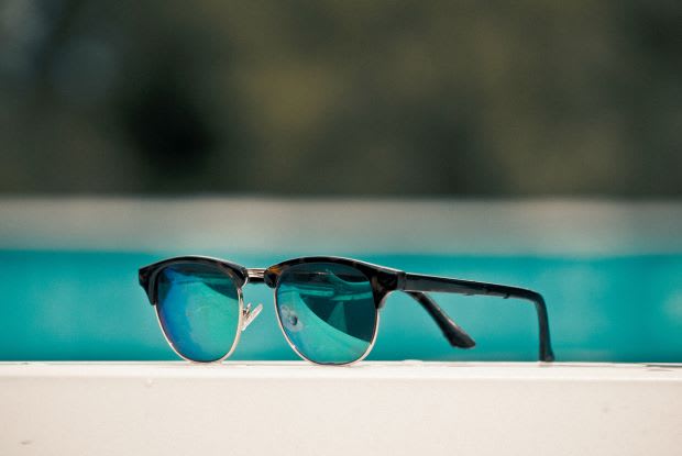 a pair of sunglasses sitting by the poolside