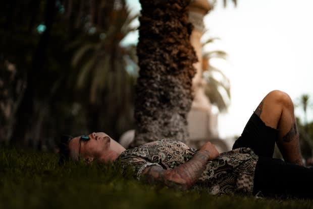 man lying below a tree