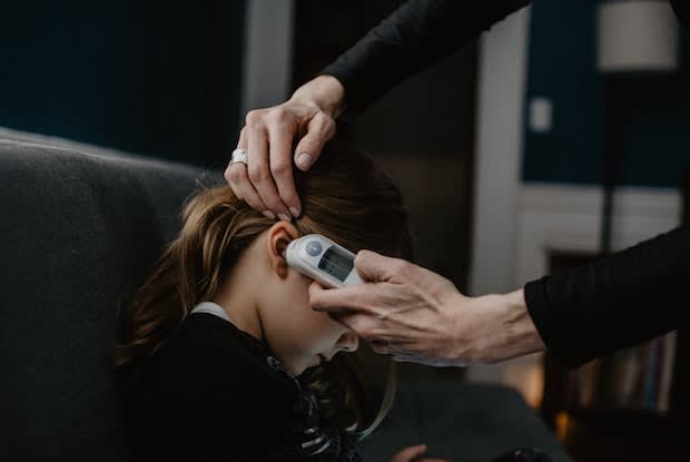 a child getting their temperature taken