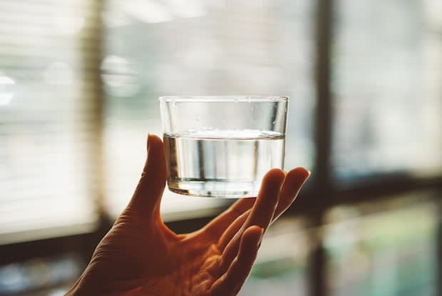 a person holding a glass of water