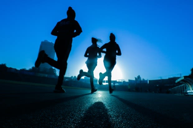 three people going for a run at sunset