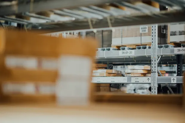 a warehouse with shipping crates and cardboard boxes on a industrial shelf