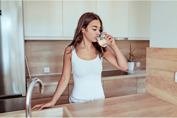 a woman drinking a glass of water