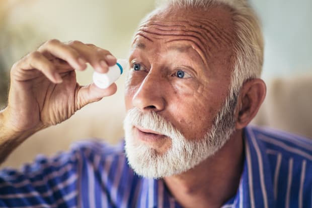 a man putting eyedrops in