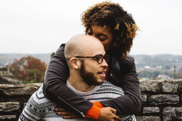 a woman hugging a bald man