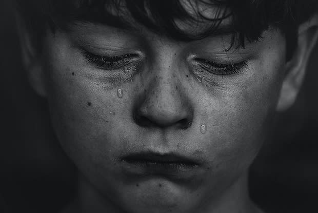 a black and white image of a crying boy