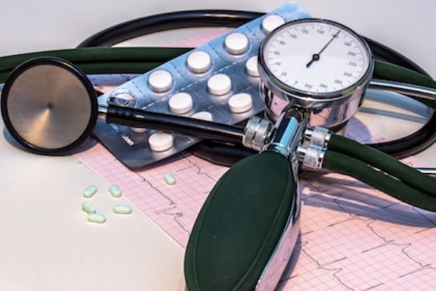 An image showing a stethoscope, EKG reading, medication and blood pressure gage