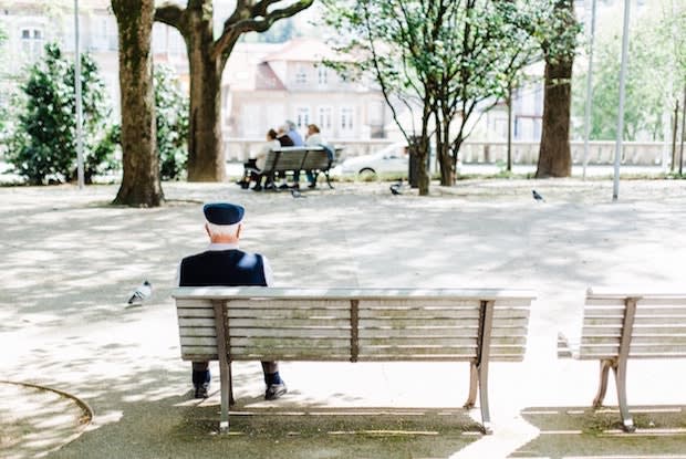 An older man sitting alone on a bench