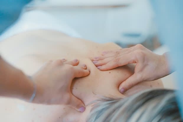 hands massaging a person’s back