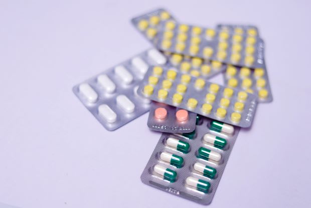 several packets of pills on a purple background