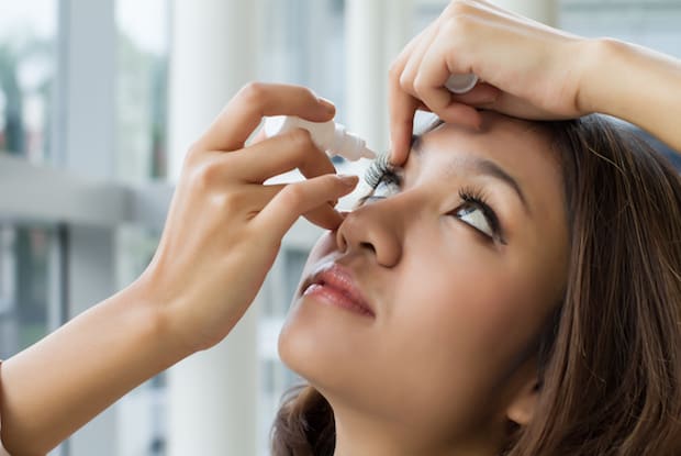 a woman administering eyedrops