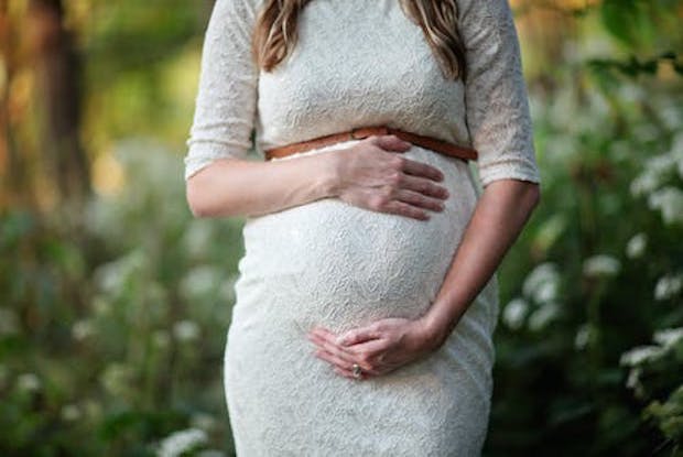 A pregnant woman holding her stomach