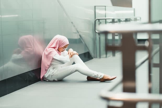 a woman sitting next to an escalator