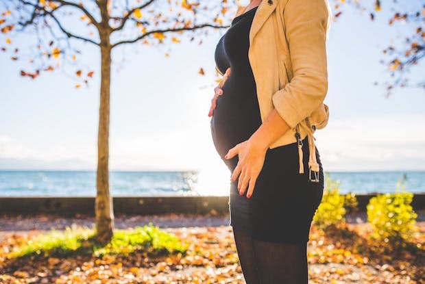 A pregnant woman holding her stomach