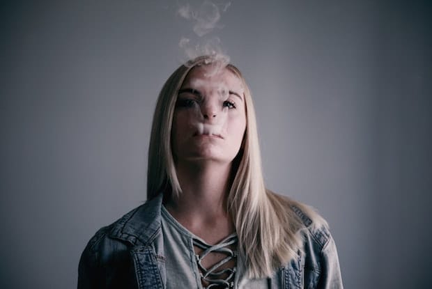 a woman blowing smoke out of her mouth