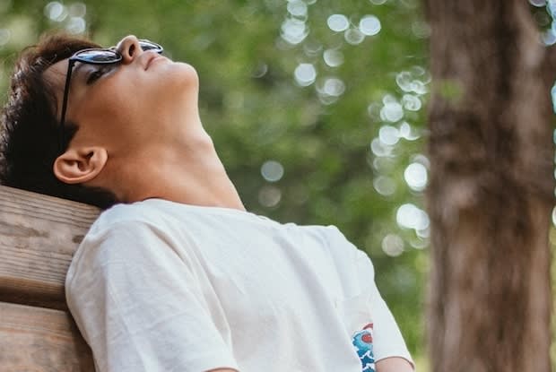 a tired teenager resting on a park bench