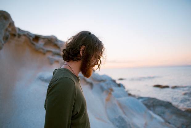 a man with long hair looking down