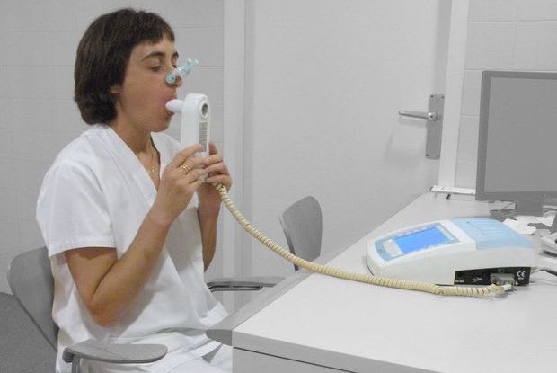 a woman taking a spirometry machine