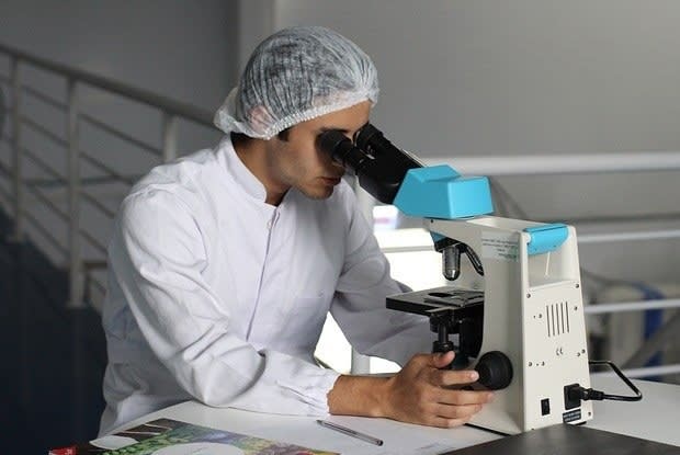 a scientist looking into a microscope