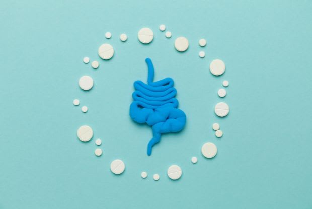 constipation pills surrounding a cut-out of the gastrointestinal system