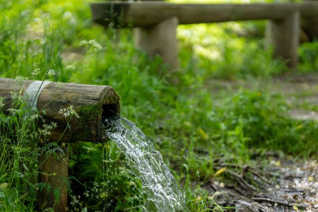 water coming out of a wooden pipe