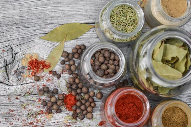 A variety of several different herbs and spices in glass jars