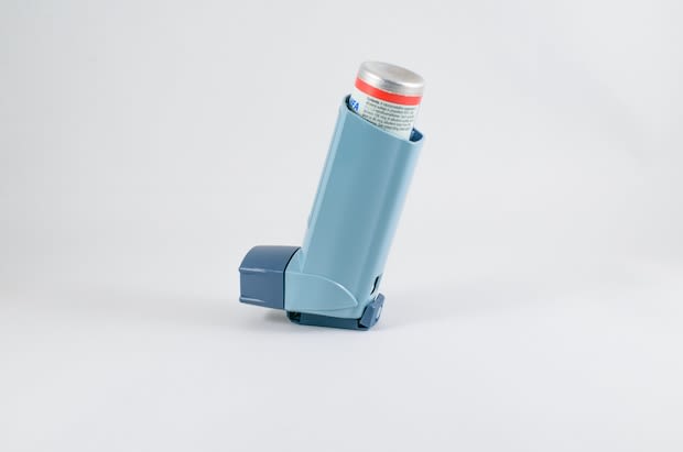 A quick-relief asthma inhaler in front of a plain background