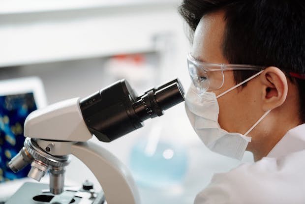 A scientist looking through a microscope