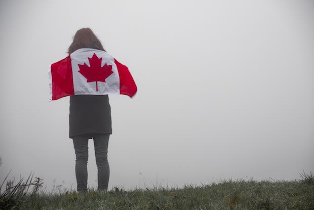 a woman holding a canadian flag on her shoulders