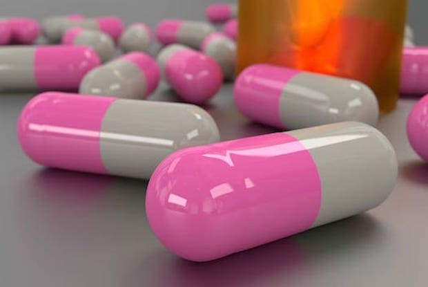 A close up of pink and white medication capsules