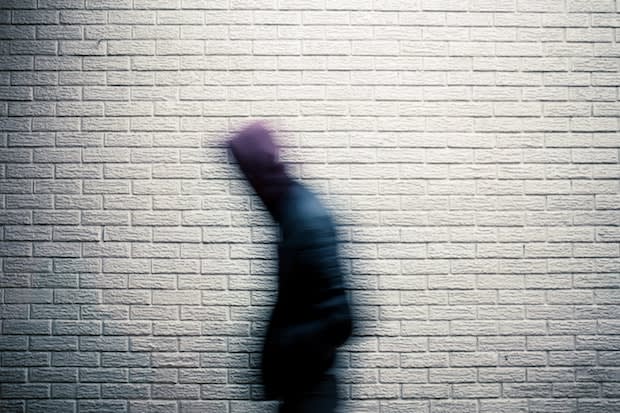 a man looking blurry in front of a white wall