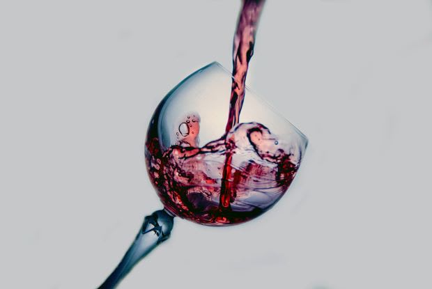 wine pouring into a tilted wine glass