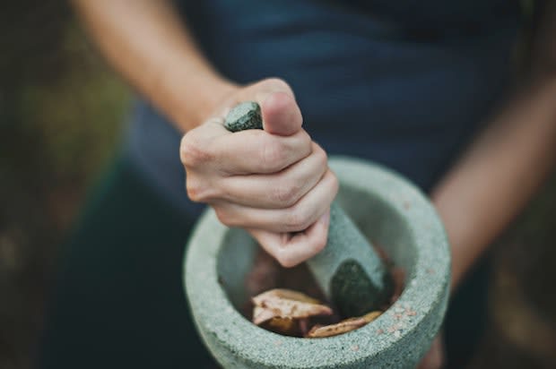 a hand grinding herbs