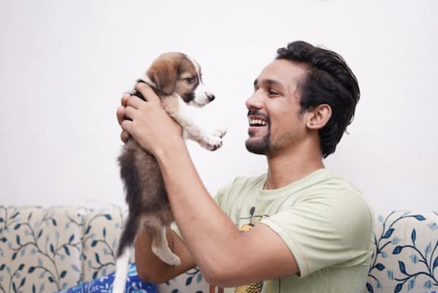 a man playing with a puppy