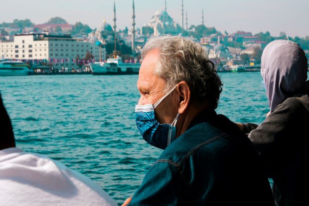 a man wearing a mask, overlooking a bay