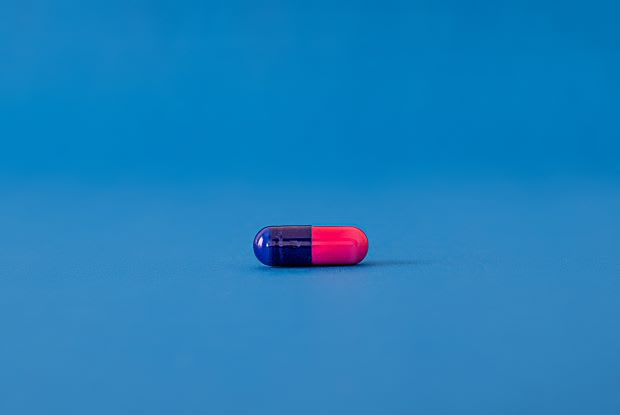 a blue and pink pill on a blue background