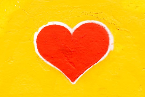 a heart graffiti artwork on a yellow wall