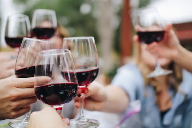 people clinking wine glasses together