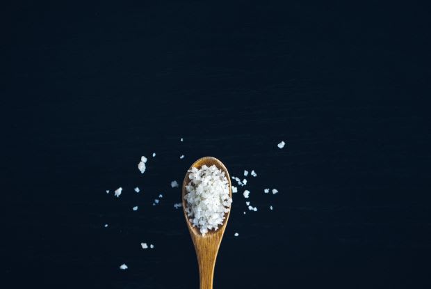 a spoonful of salt on a black background