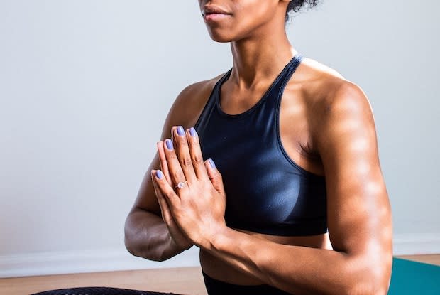 Peaceful woman in seated pose meditating with hands touching 