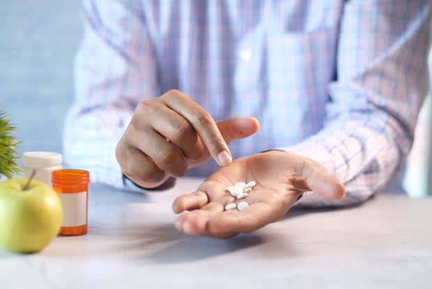 a person holding pills in their palm