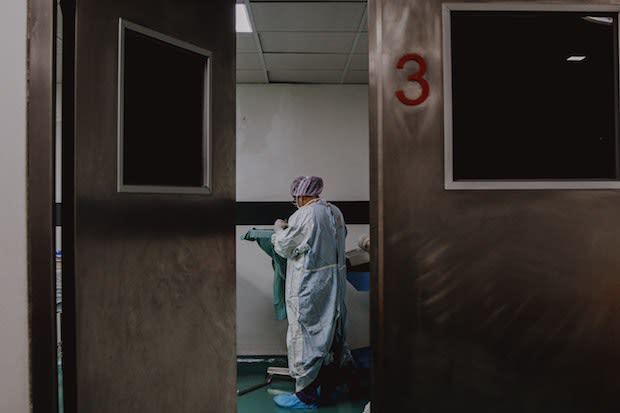 a view of a doctor through a hospital door